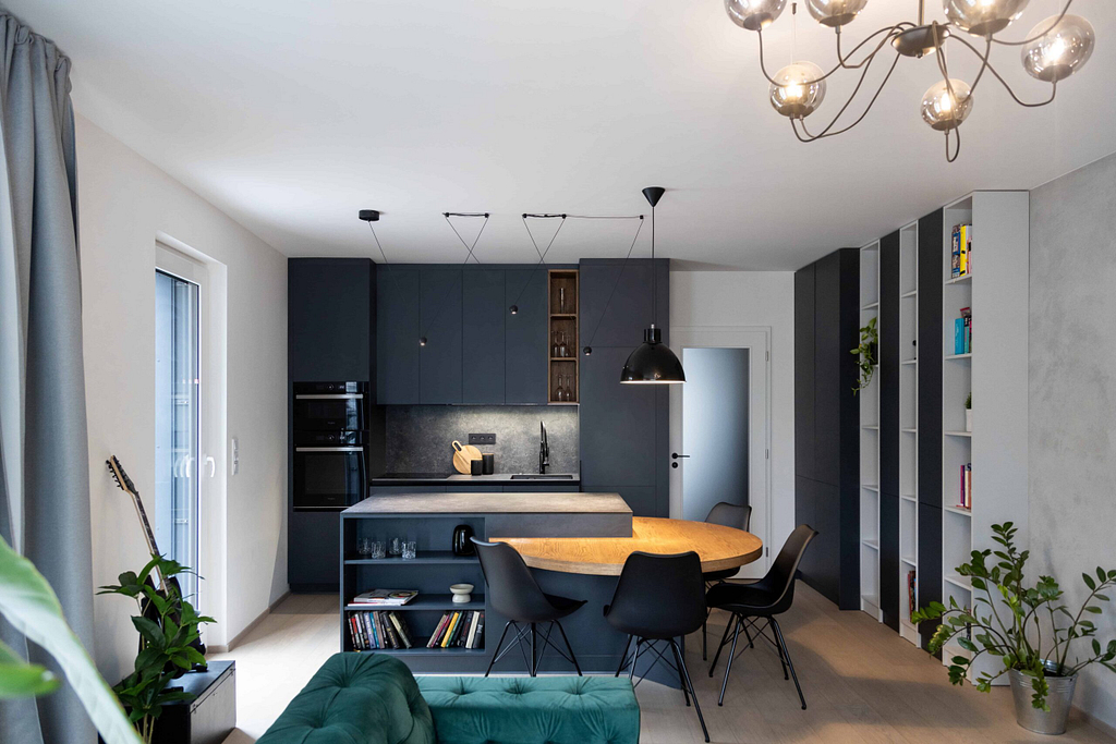 pánský byt s černou kuchyní, obývací pokoj s černou kuchyní s betonovou stěrkou, zelená pohovka, Ing. arch. Ivana Volková, Architektiv,